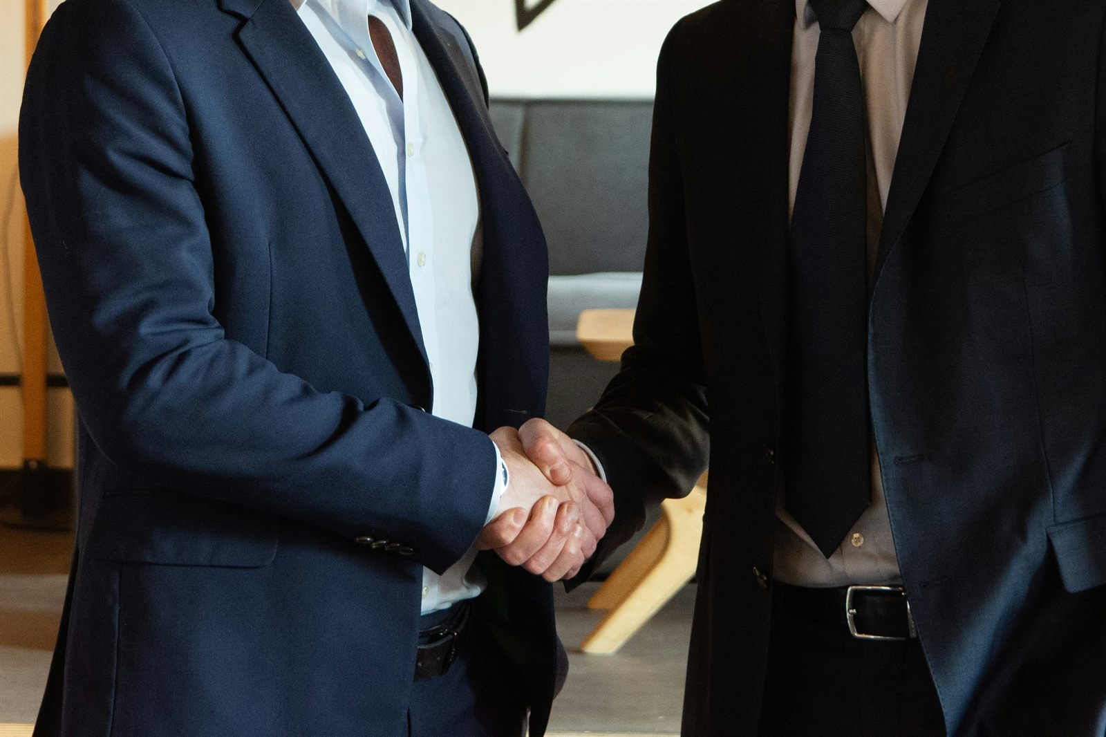 Two business partners shake hands on a government contract.